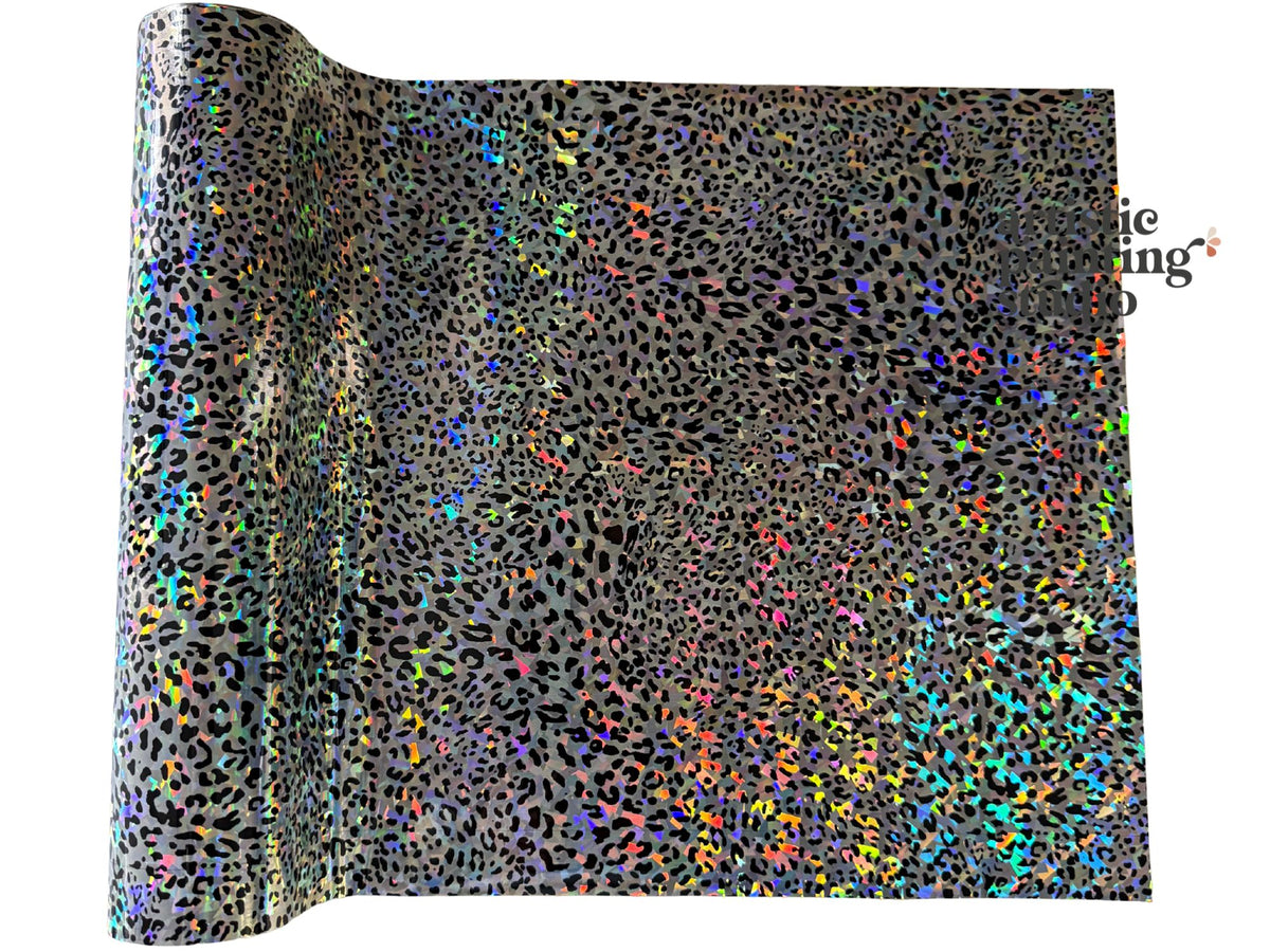 Roll of holographic transfer foil with leopard print pattern on a white background