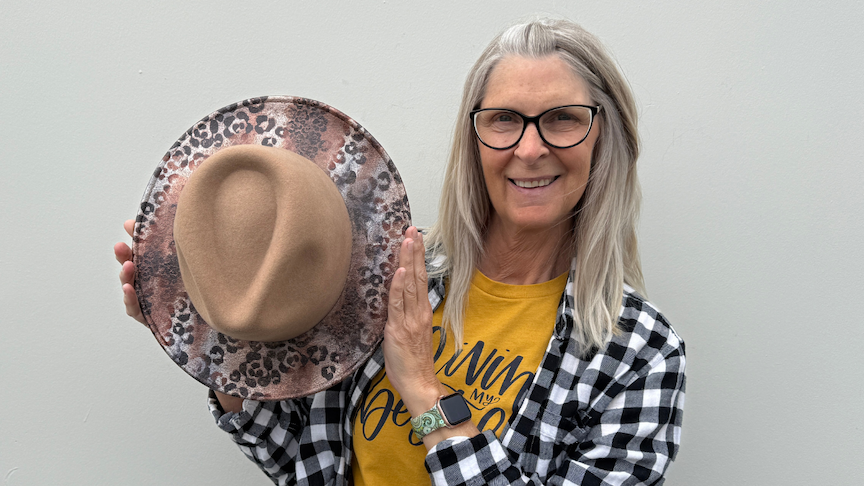 Woman holding hat with transfer foils applied to it