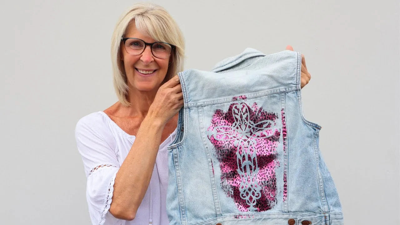 Load video: Jenn uses a stencil and foils to add a beautiful stencil cross to a jean vest.